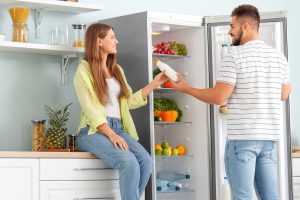 Un jeune couple qui a le défi de choisir un réfrigérateur-کاماپرس