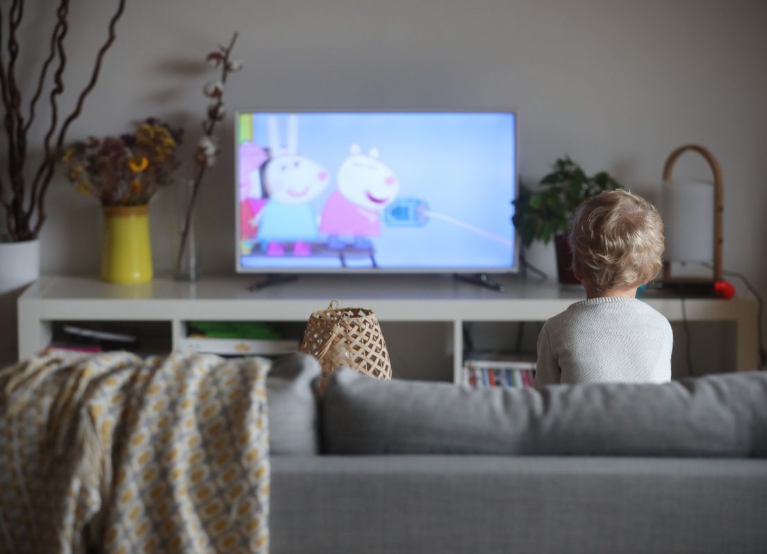 Illustration d'un enfant qui regarde la télé. Les écrans sont déconseillés pour les plus petits.