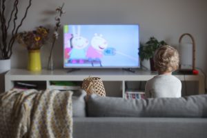 Illustration d'un enfant qui regarde la télé. Les écrans sont déconseillés pour les plus petits.