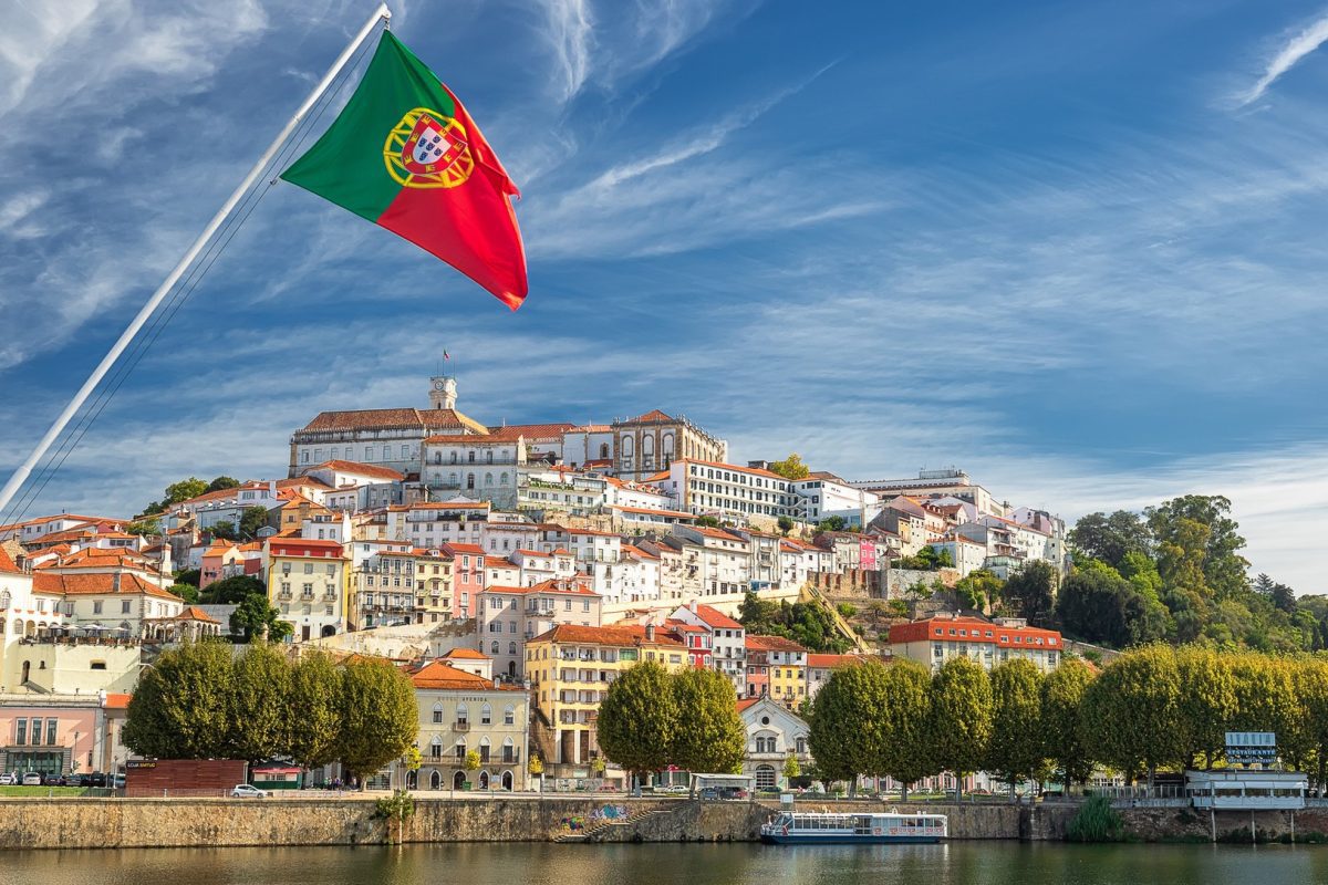 View on the old university city of Coimbra and the medieval capital of Portugal with Portuguese flag, Europe-کاماپرس