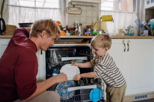 Une personne mettant la vaisselle au lave-vaisselle-کاماپرس